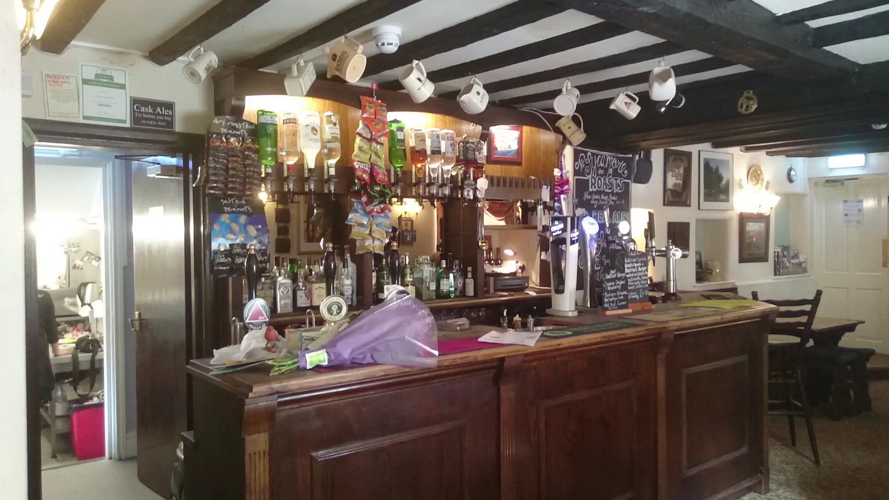 The bar, with beer pumps, low beams and bottles behind