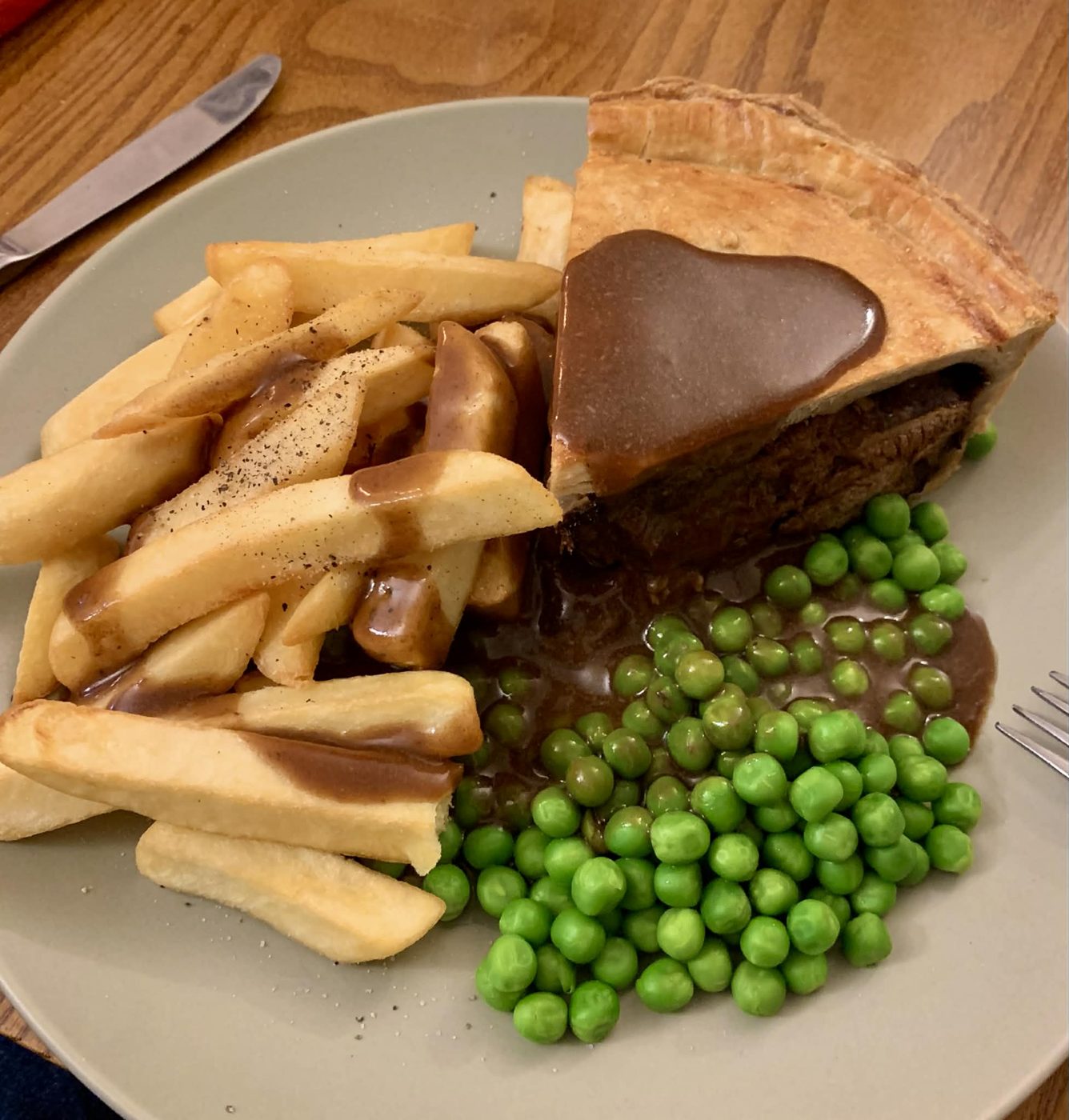 A pie with chips and peas